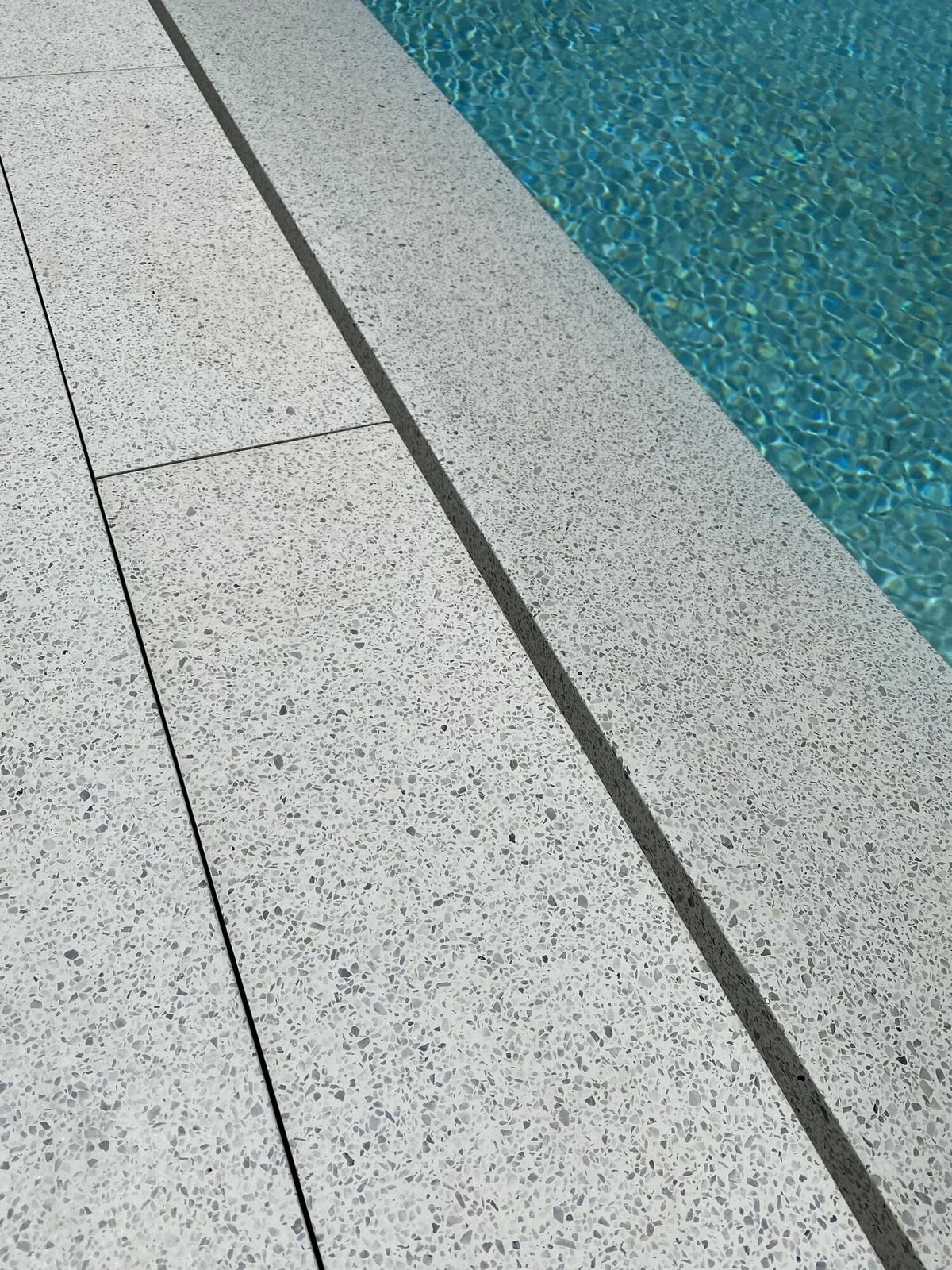 Borde de piscina con canal en terrazo