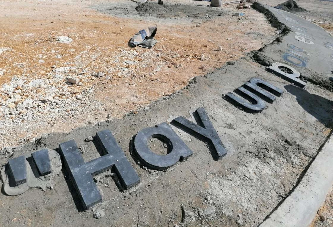 Letras de concreto en obra formando la frase Hay un país