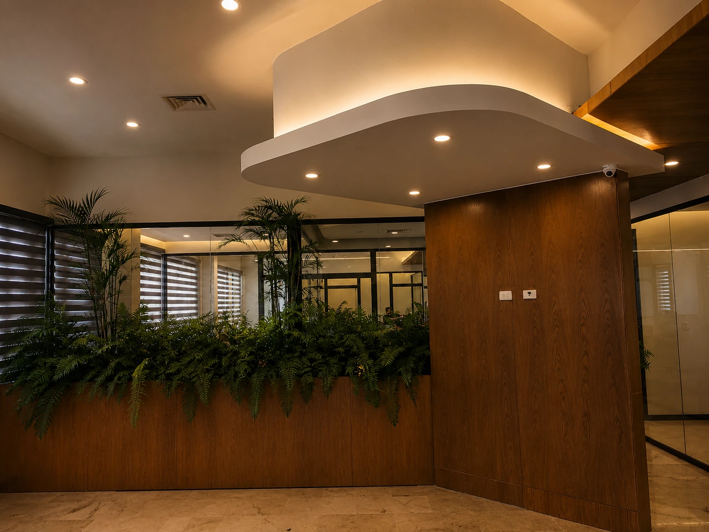 Recepción de Oficinas FIMED con cielo raso curvo y jardineras